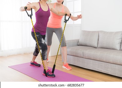 powerful attractive female fitness girl using resistance band training body with her workout teacher at home. - Powered by Shutterstock