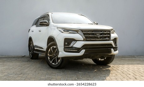 Powerful and bold: The imposing front view of a white Toyota Fortuner, showcasing its rugged design, distinctive grille, and modern LED lighting for any adventure.