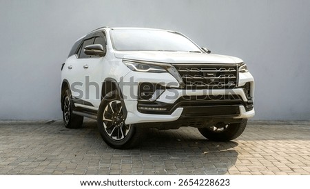 Powerful and bold: The imposing front view of a white Toyota Fortuner, showcasing its rugged design, distinctive grille, and modern LED lighting for any adventure.