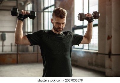 Powerful Brutal Adult Bearded Male In Sportswear Doing Dumbbell Overhead Press During Intense Workout In Gym