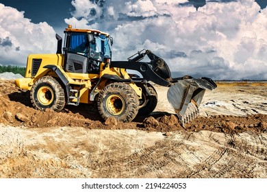 Powerful bulldozer or loader moves the earth at the construction site against the sky. An earthmoving machine is leveling the site. Construction heavy equipment for earthworks - Shutterstock ID 2194224053