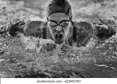 Powerful butterfly stroke swimming. Frozen motion, black and white