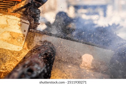 Powerful chainsaw cutting through wood at a busy construction site during the daytime. A chainsaw operates vigorously, sending sawdust flying in the air as it cuts through timber. - Powered by Shutterstock