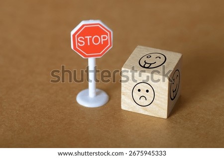A powerful conceptual image featuring a stop sign beside a wooden block with a sad face, symbolizing the urgent call to halt bullying and protect emotional well-being.
