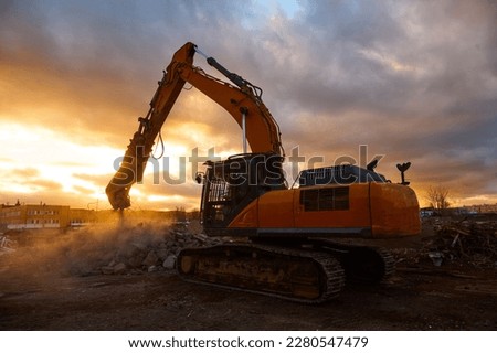 Powerful crusher destroys armored cement leftovers at sunset