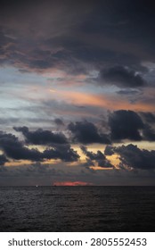 Powerful Dark Clouds Hanging Over the Ocean Horizon with Colorful Sunset Twilight Sky
