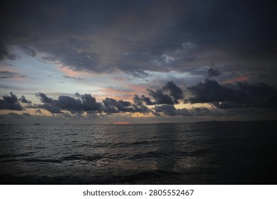 Powerful Dark Clouds Hanging Over the Ocean Horizon with Colorful Sunset Twilight Sky
