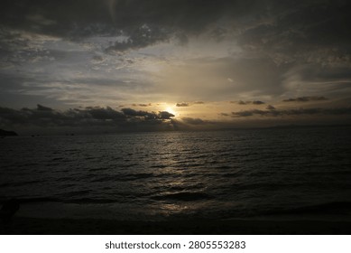 Powerful Dark Clouds Hanging Over the Ocean Horizon with Colorful Sunset Twilight Sky
