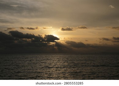 Powerful Dark Clouds Hanging Over the Ocean Horizon with Colorful Sunset Twilight Sky
