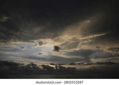 Powerful Dark Clouds Hanging Over the Ocean Horizon with Colorful Sunset Twilight Sky

