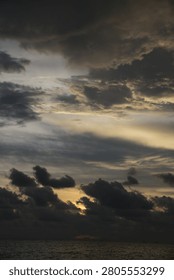 Powerful Dark Clouds Hanging Over the Ocean Horizon with Colorful Sunset Twilight Sky
