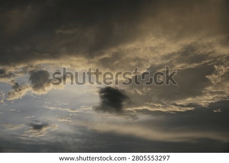 Powerful Dark Clouds Hanging Over the Ocean Horizon with Colorful Sunset Twilight Sky
