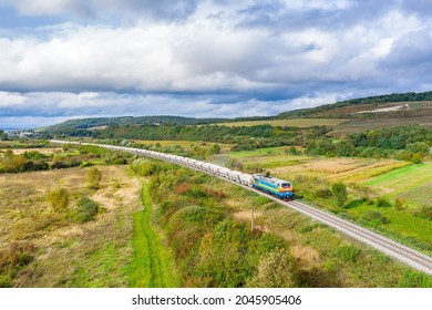 A Powerful Diesel Locomotive TE33 Pulls A Train Of Freight Cars Loaded With Raw Materials For The Production Of Cement.  Railway Line Located In The Mountains.  View From Above. Ukrainian Railways