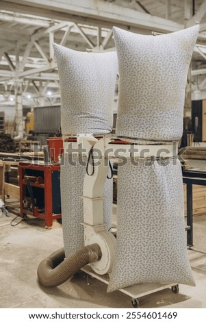 Powerful dust collector machine with filter bags working in a carpentry workshop, ensuring a clean and healthy environment