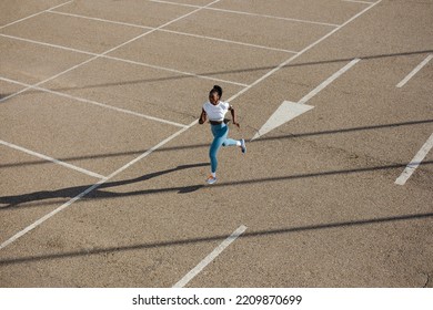 Powerful female athlete running on urban asphalt. Sporty young black woman training in the city. - Shutterstock ID 2209870699