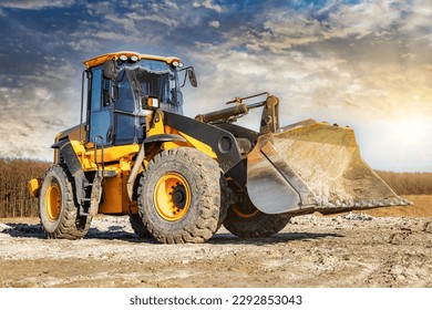 Powerful front wheel loader or bulldozer working on a quarry or construction site. earthworks in construction. Powerful modern equipment for earthworks - Shutterstock ID 2292853043