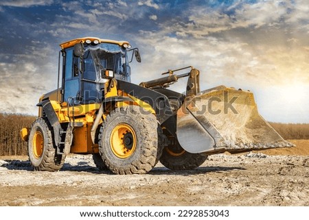 Powerful front wheel loader or bulldozer working on a quarry or construction site. earthworks in construction. Powerful modern equipment for earthworks