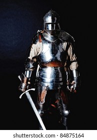 Powerful heavy fighter with sword and helmet. Isolated on black background.