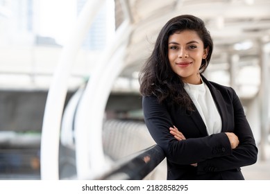 Powerful hispanic woman in business suit standing with arm crossed ourdoors in the city - Shutterstock ID 2182858295