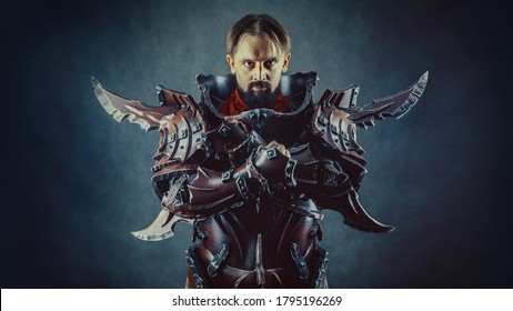 Powerful knight in the armor. Dark background.
