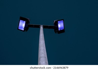 Powerful LED Light On A Aluminum Metal Pole, Dark Blue Sky Background. Concept Sport Event, Game. Modern Light Source. Blue Light Color.