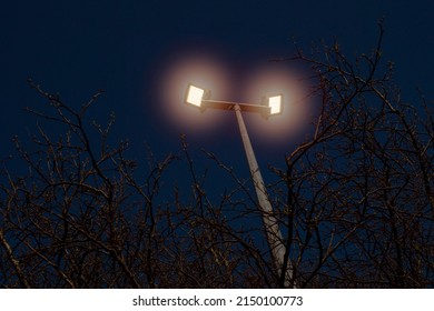 Powerful LED Light On A Aluminum Metal Pole, Dark Blue Sky Background. Concept Sport Event, Game. Modern Light Source. Warm Light Color.