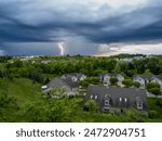 A powerful lightning bolt electrifies the evening sky above a U.S. neighborhood