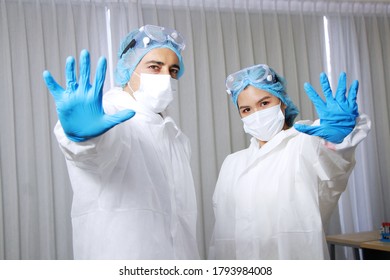 Powerful of Medical team in Personal Protective Equipment or PPE clothing and Healing for patient and showing stop hand sign for Covid-19 virus pathogens and inhibit the spread of germs. - Shutterstock ID 1793984008