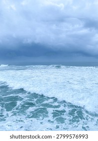 Powerful ocean waves under dramatic storm clouds create a mesmerizing seascape, capturing the beauty and energy of nature.