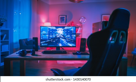 Powerful Personal Computer Gamer Rig with First-Person Shooter Game on Screen. Monitor Stands on the Table at Home. Cozy Room with Modern Design is Lit with Pink Neon Light. - Shutterstock ID 1430140070