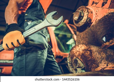 Powerful Professional Mechanic. Heavy Duty Equipment Maintenance. Industrial Concept. Caucasian Men with Large Iron Wrench in a Hand.