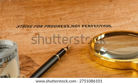 A powerful quote, Strive for Progress Not Perfection, sits on a warm wooden surface.