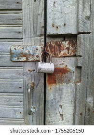 Powerful Steel And Rusty Closed Padlock On A Wooden Barn Door