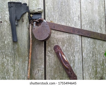 Powerful Steel And Rusty Closed Padlock On A Wooden Barn Door