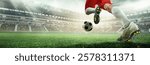 Powerful strike. Soccer player in red shorts making jump kick towards ball in stadium under sunlight. 3D model of arena. Speed, motion, goal attempt. Concept of sport, competition, winning moment.