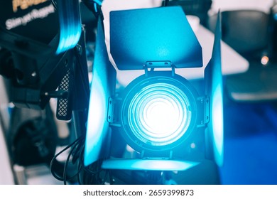 Powerful turquoise light source. Continuous light spotlight. Professional stage monoblock with curtains. Narrow beam light source. Lighting equipment, Fresnel lens