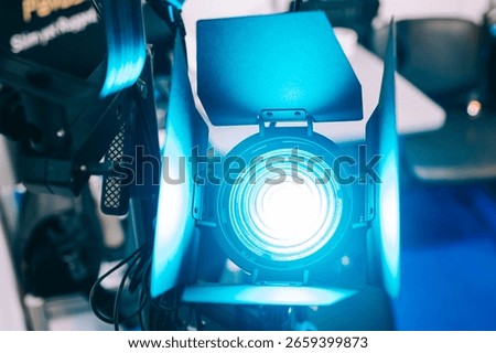 Powerful turquoise light source. Continuous light spotlight. Professional stage monoblock with curtains. Narrow beam light source. Lighting equipment, Fresnel lens