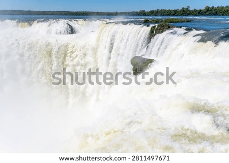 Powerful water cascades down devil's throat, a dramatic section of iguazu falls, argentina, displaying immense natural force