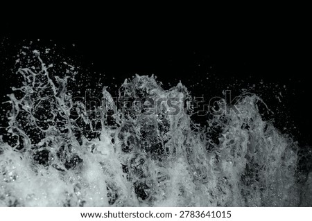 A powerful wave crashes dramatically against a dark background