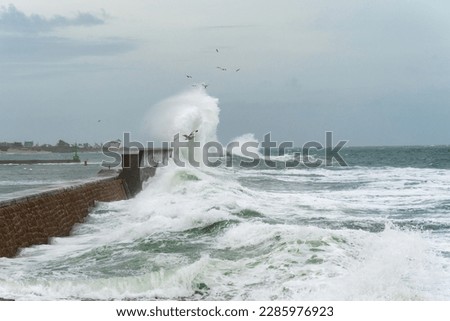 Powerful waves crash on a pier in Lesconil in Brittany