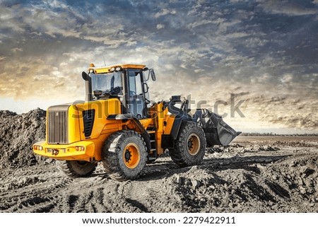 Powerful wheel loader or bulldozer working on a quarry or construction site. Earthworks in construction. Powerful modern equipment for earthworks