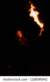 Powerful Woman Catching Fire On A Spray Graffiti Can. Girl Holding A Chemical Flame Thrower High Sparks In  An Occult Mystic Orange And Dark Background. Superhero Girl And Underground Youth Explosion