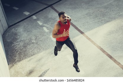 Powerful Young Man Sprinting. Fit Motivated Black Athlete Running On Hot Summer In The City.