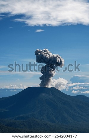 Powerfull Volcanic Eruption With Ash Cloud Rising into the Blue Sky - Natural Disaster Concept