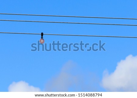 Powerline bird flight diverter against a blue sky background