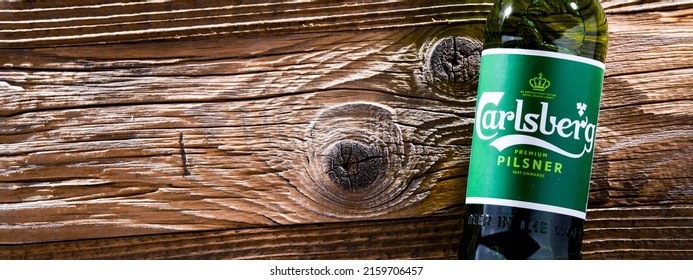 POZNAN, POL - APR 13, 2022: Bottle of Carlsberg pale lager beer produced by Carlsberg Group, a Danish brewing company founded in 1847 with headquarters located in Copenhagen, Denmark