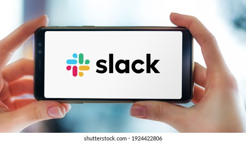 POZNAN, POL - FEB 6, 2021: Hands Holding Smartphone Displaying Logo Of Slack, A Proprietary Business Communication Platform Developed By American Software Company Slack Technologies