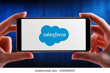 POZNAN, POL - FEB 6, 2021: Hands holding smartphone displaying logo of Salesforce.com, an American cloud-based software company. It provides customer relationship management (CRM) service