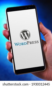 POZNAN, POL - FEB 6, 2021: Hand holding smartphone displaying logo of WordPress, a free and open-source content management system (CMS) written in PHP and paired with a MySQL or MariaDB database