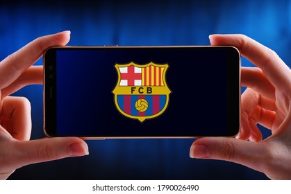 POZNAN, POL - JUN 20, 2020: Hands holding smartphone displaying logo of Futbol Club Barcelona, a Spanish professional football club based in Barcelona, Catalonia, Spain